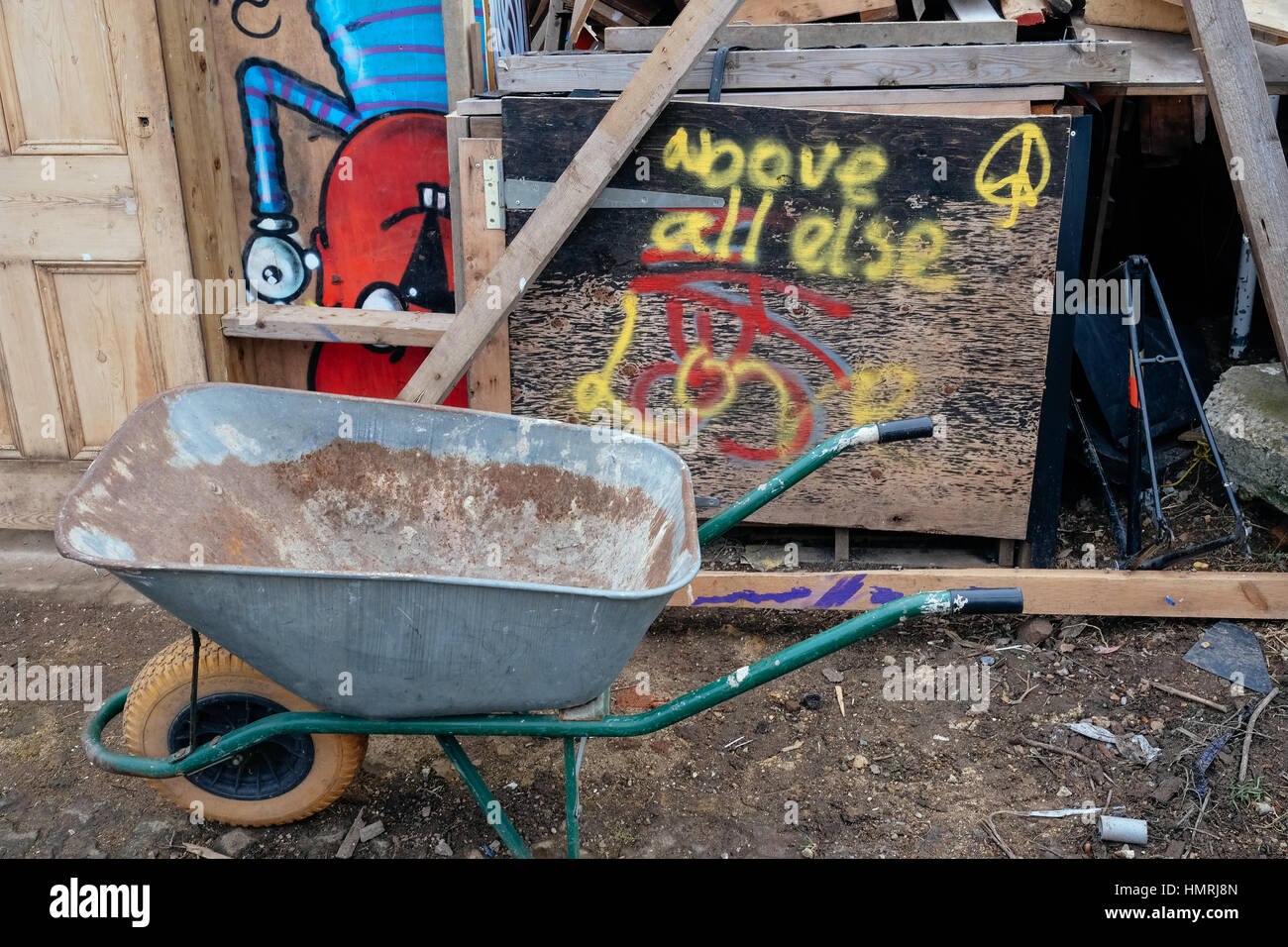 "Vor allem Liebe' Graffiti gesprüht über das Holzbrett; Garten Warenkorb an der Seite an die nomadische Gemeinschaft Garten aus Brick Lane, London. Stockfoto