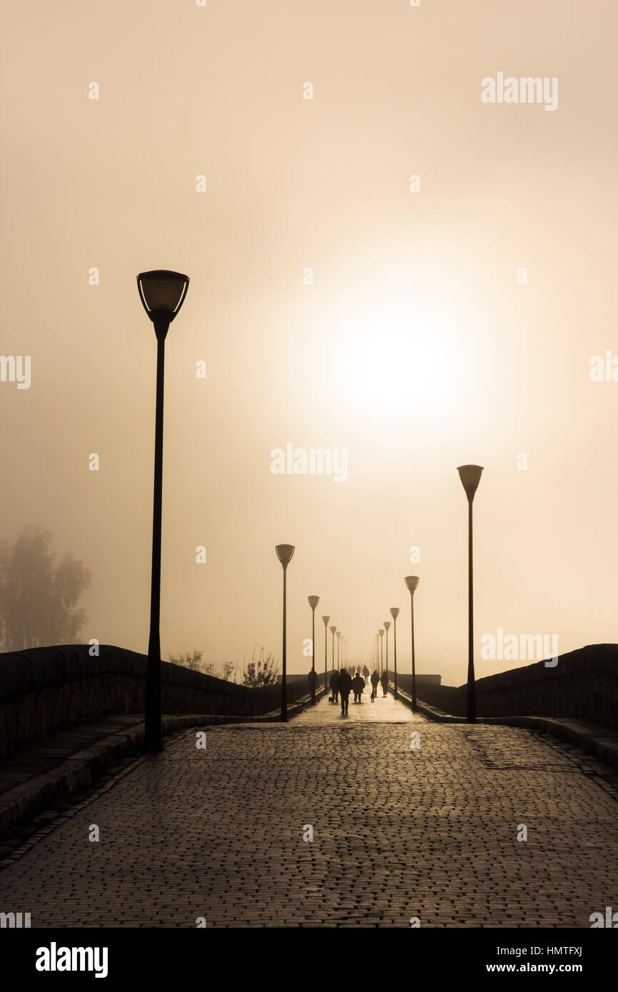 Merida, Extremadura, Spanien.  Nebligen Sonnenuntergang über die Römerbrücke. Stockfoto