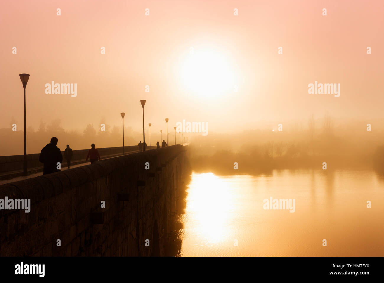 Merida, Extremadura, Spanien.  Nebligen Sonnenuntergang über die Römerbrücke. Stockfoto