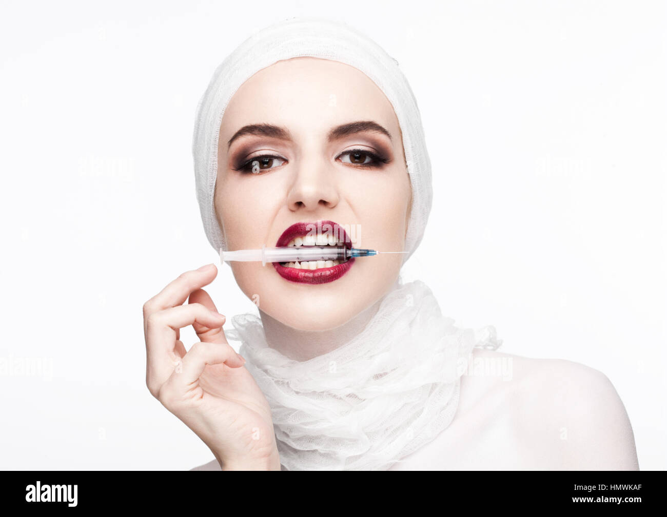 Schönes Model Holding Spritze in ihre Lippen für plastische Chirurgie dieses auf weißem Hintergrund Stockfoto