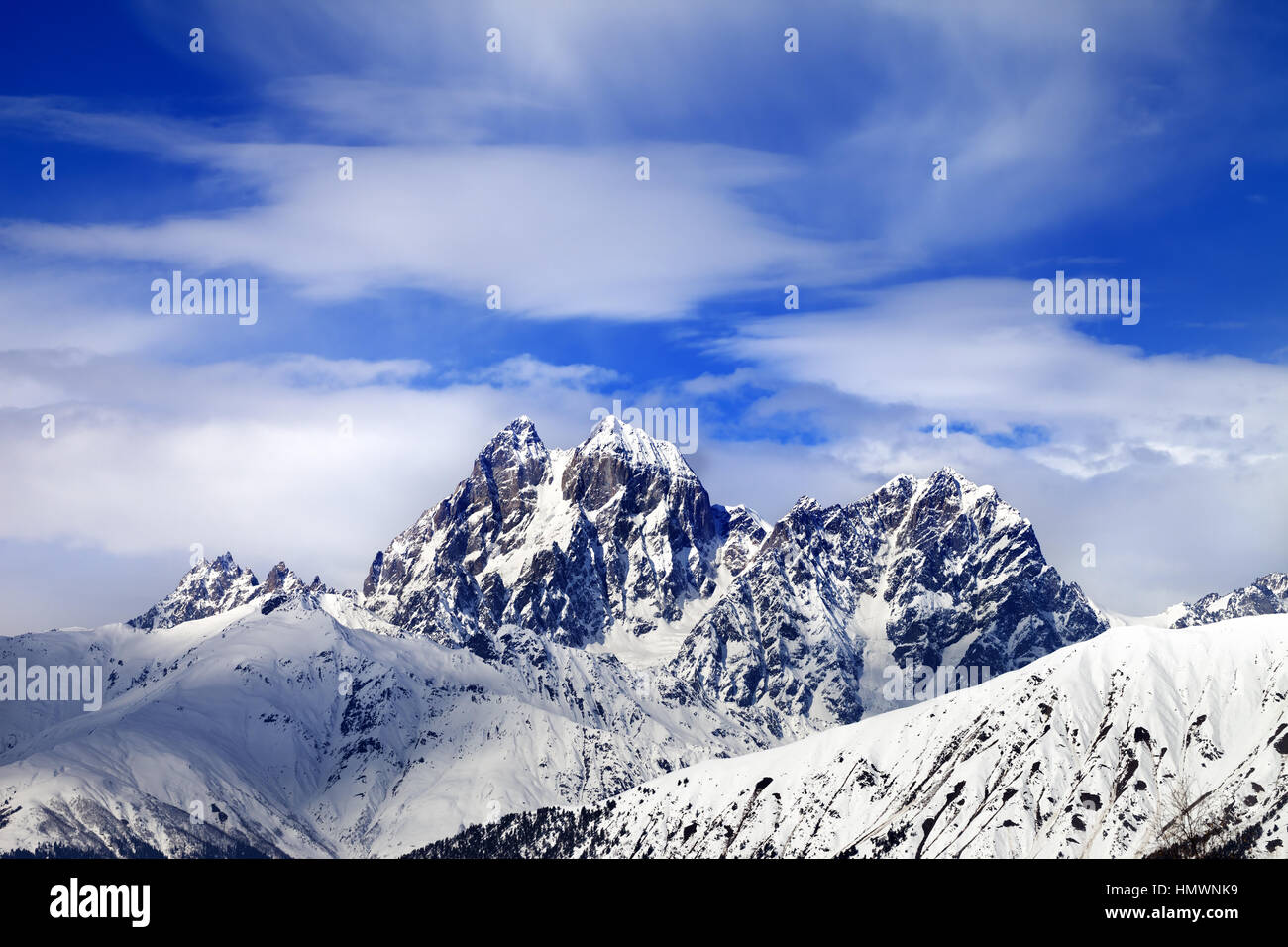 Berge und blauer Himmel mit Wolken im Winter Schnee. Kaukasus-Gebirge. Svaneti Region Georgiens. Reittiere Uschba und Heldenfestung. Stockfoto