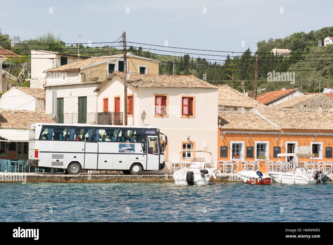 Trainer, sorgfältig navigieren entlang der sehr schmale Straße in der kleinen griechischen Angeln und Urlaub Dorf von Loggos auf der winzigen Insel Paxos Stockfoto