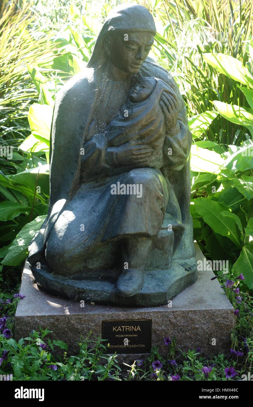 Mutter mit Kind Steinskulptur.  Die Mutter der sitzt, trägt einen Schal und hält ihr Kind in eine Decke gehüllt. Starke Liebe Emotion. Stockfoto