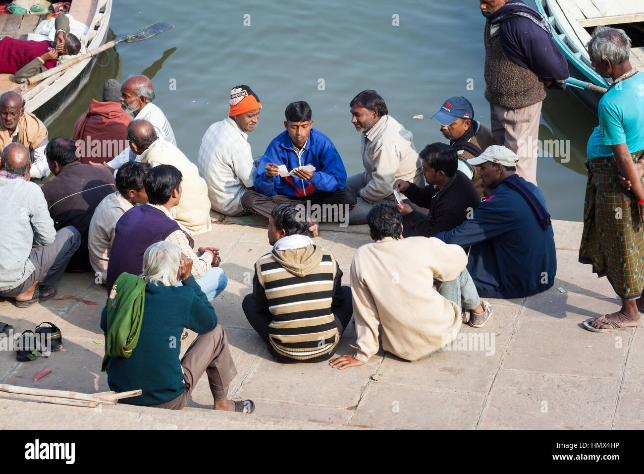 VARANASI, Indien - 4. Januar 2015: Eine Gruppe von Männern Spielkarten bei Prachin Hanuman Ghat am Ufer des Flusses Ganges. Stockfoto