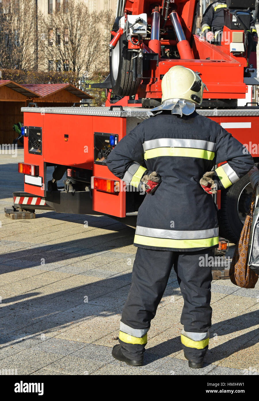 Feuerwehrmann steht neben einem Kran Stockfoto