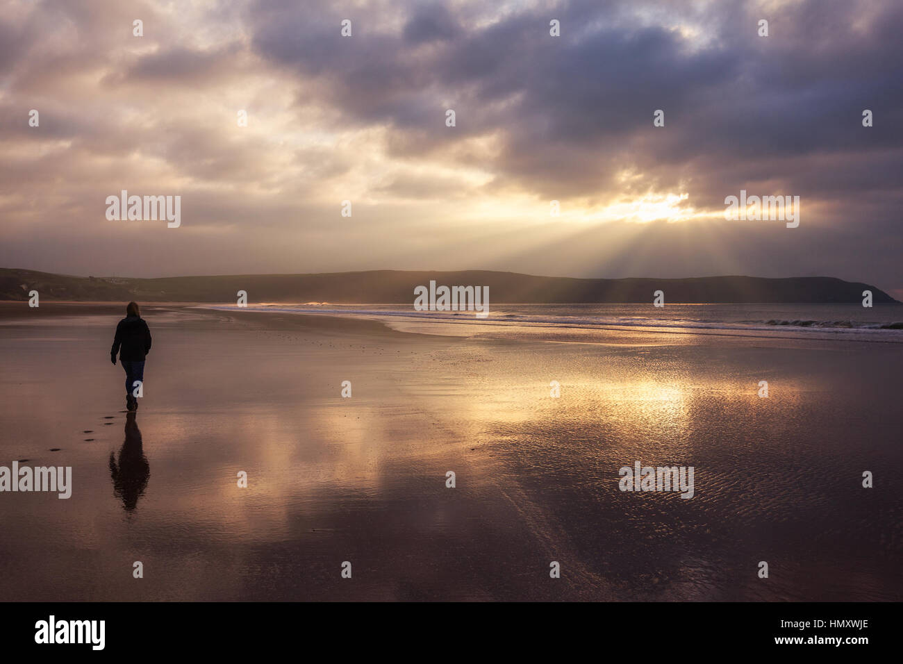 Silhouette Frau allein zu Fuß am Strand von Woolacombe Sands in North Devon, England, UK Stockfoto