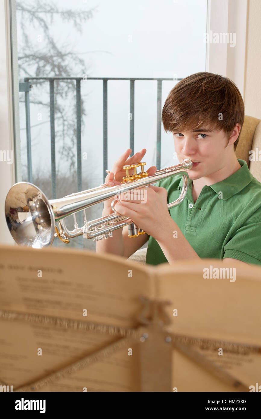 Foto von einem Teenager männlich seine Trompete zu Hause üben. Stockfoto