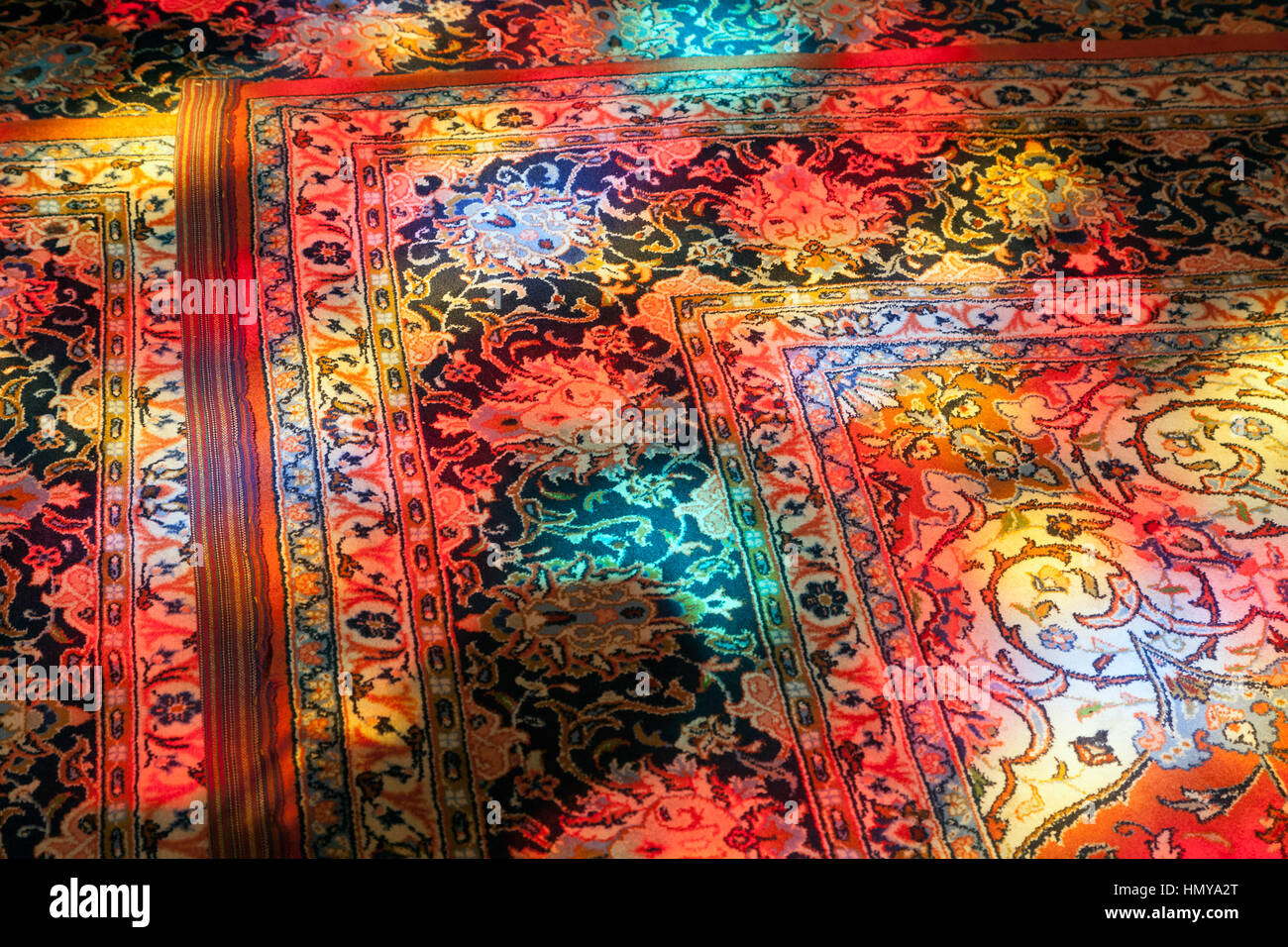 Glasmalerei-Reflexionen auf einem persischen Teppich Shiraz Schrein, Iran Stockfoto