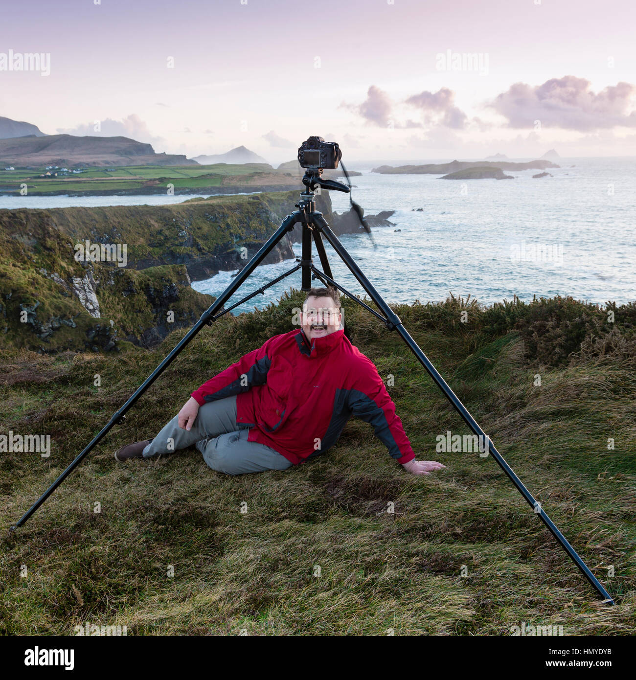 Männlichen Fotografen sitzen unter Stativ, Bary Kopf Skellig Ring, Irland Stockfoto