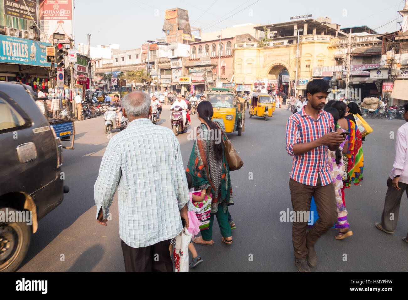 HYDERABAD, Indien - Februar 06,2017 Fußgänger jaywalking während ein Mann ein Handy benutzt in der Nähe von einer Ampel in Hyderabad, Indien Stockfoto