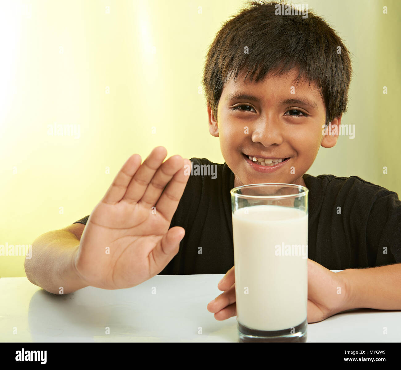 Latino Boy will nicht Milch isoliert auf gelb Stockfoto