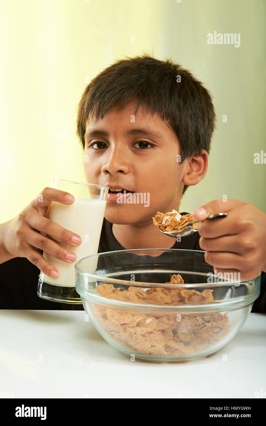 junge essen Getreide und Milch auf gelbem Hintergrund isoliert Stockfoto