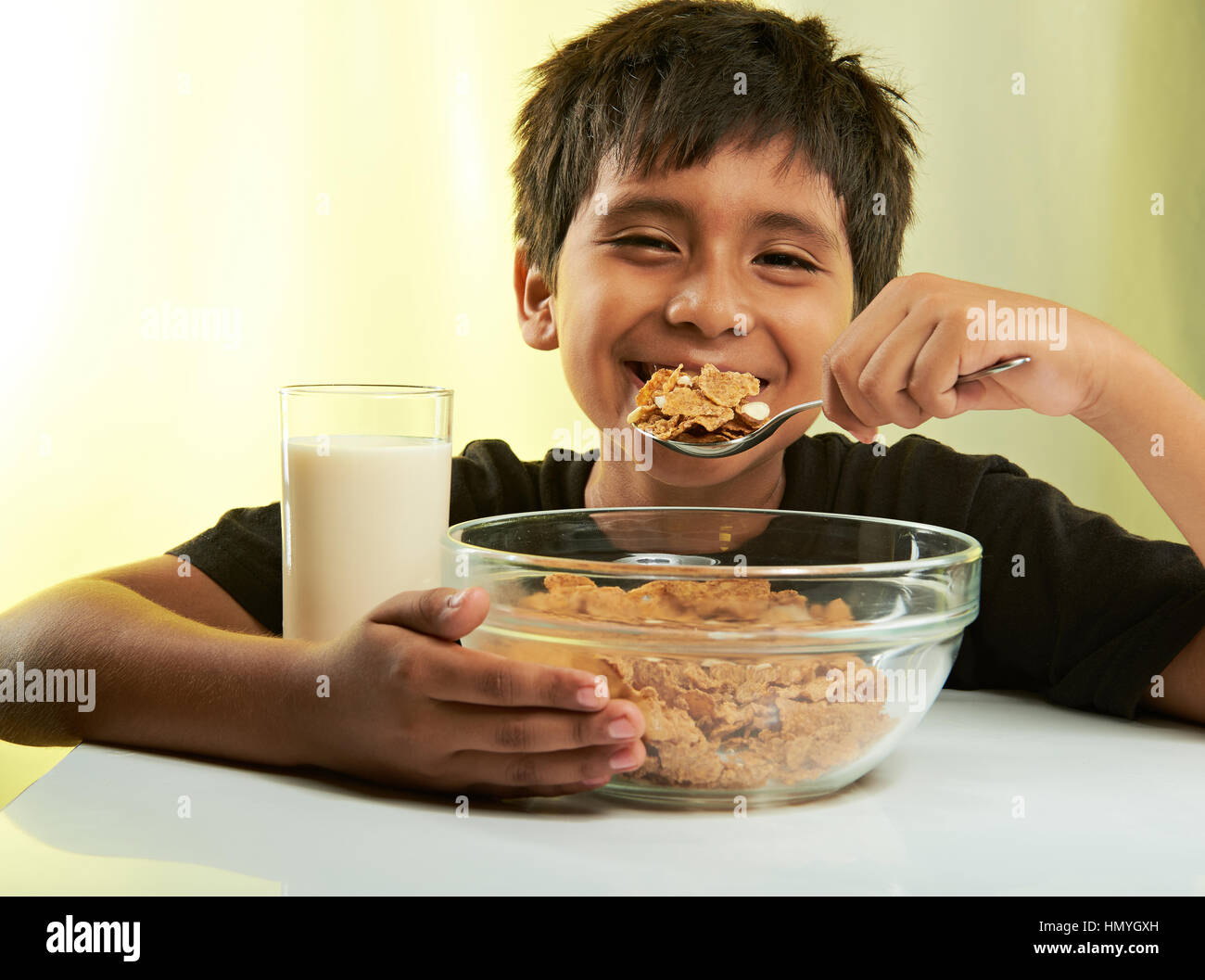fröhlicher Junge beim Frühstück auf gelbem Hintergrund isoliert Stockfoto
