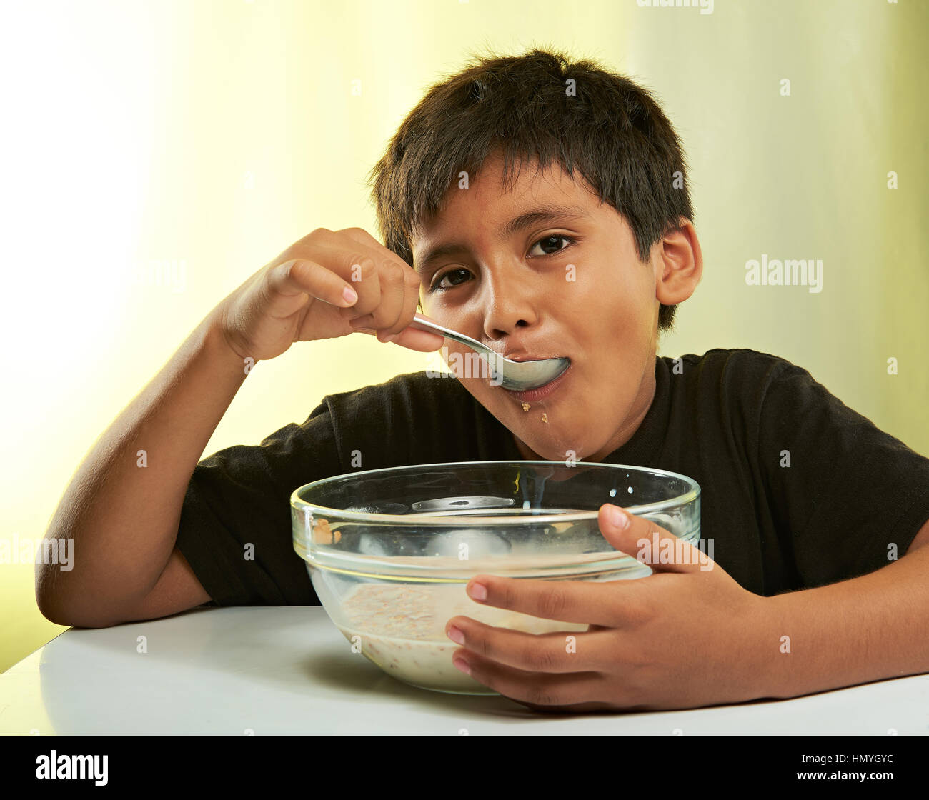 Junge mit Löffel im Mund essen Müsli Stockfoto
