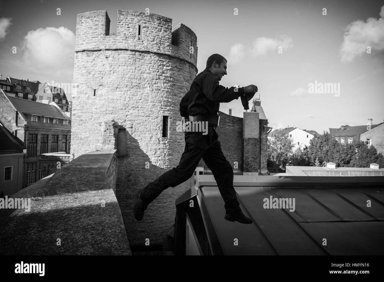 Jürmo (27) springt auf einem Dach in der Altstadt von Tallinn, Estland 20. September 2016. Stockfoto