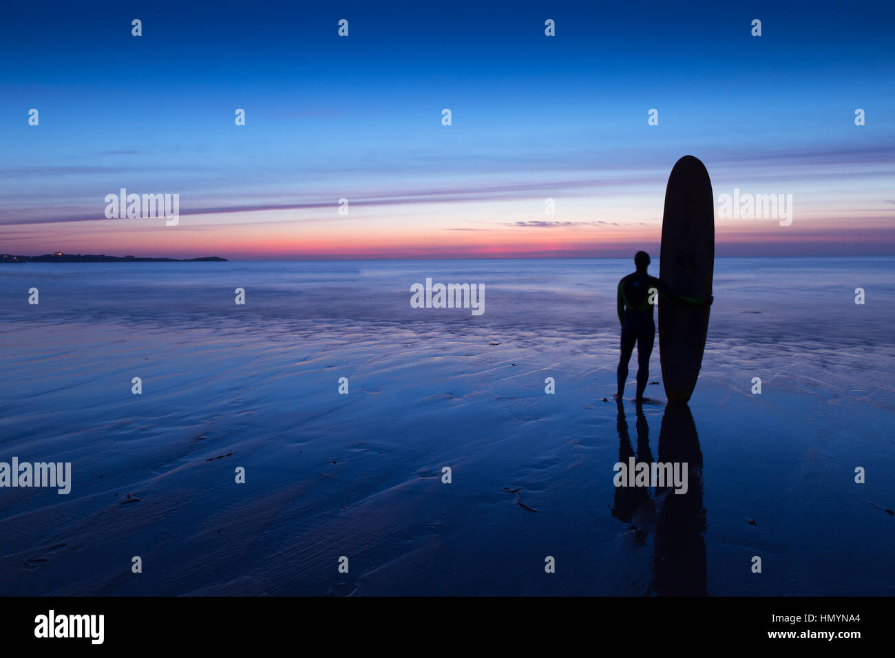 Silhouette der Surfer Mann mit Surfbrett am Strand bei Sonnenuntergang Stockfoto