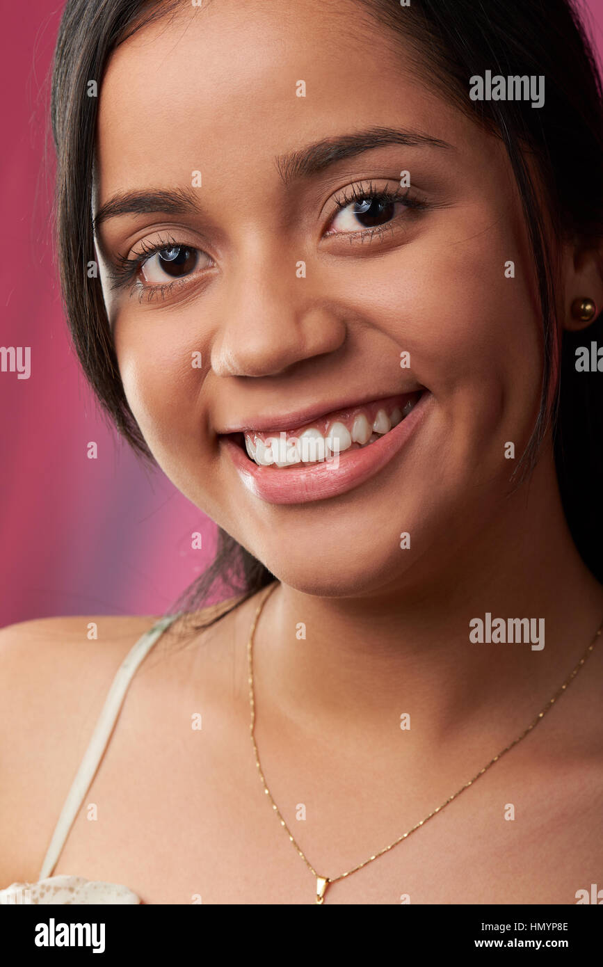 Close up Portrait of hispanic Frau Gesicht auf rotem Hintergrund isoliert Stockfoto