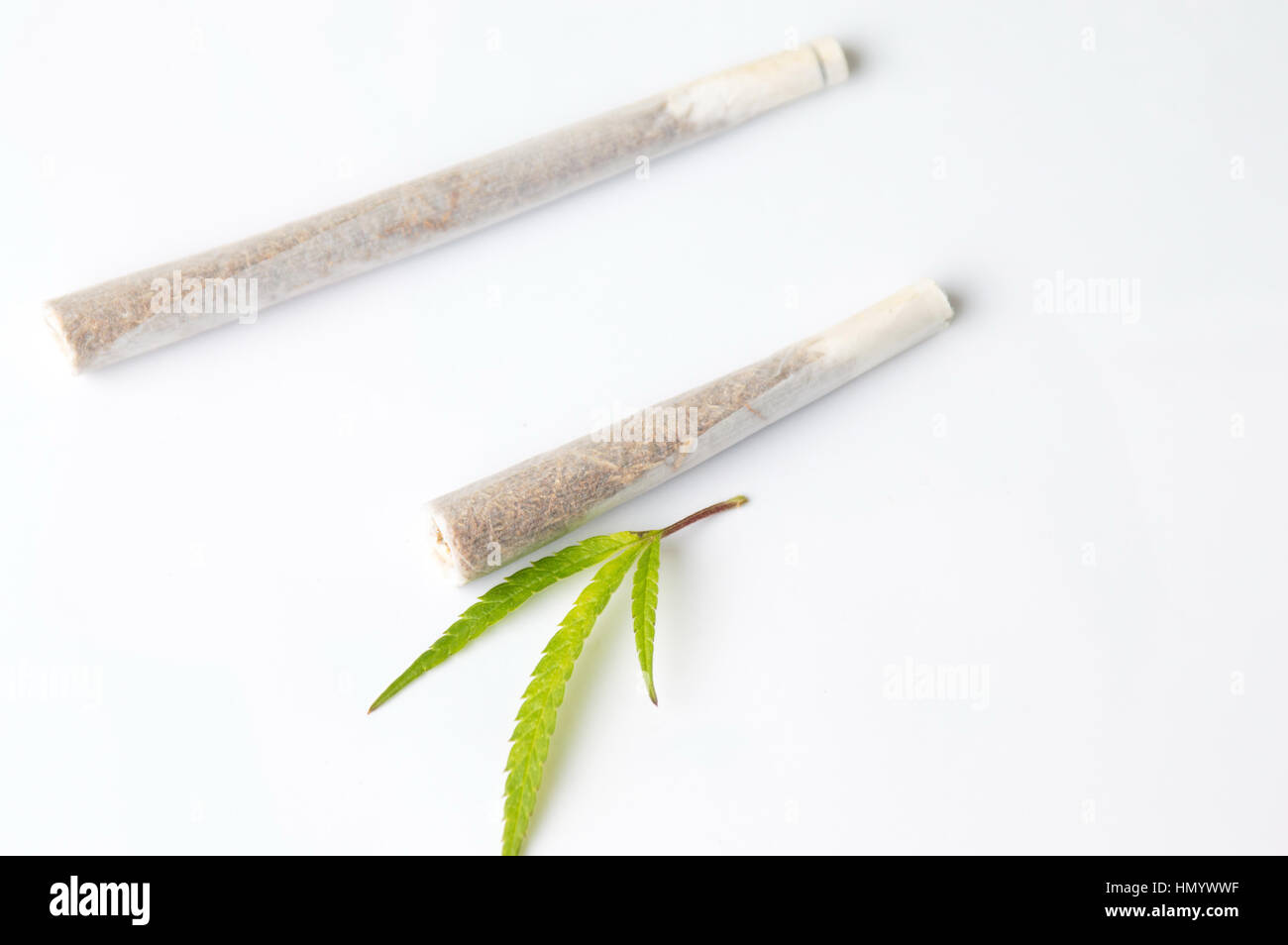 Zwei Gelenke und Marihuanablatt auf weiß Stockfoto