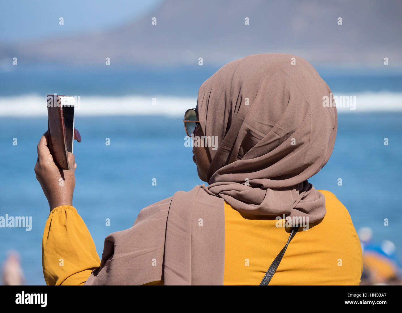 Frau trägt Hijab, Kopfbedeckungen getragen von muslimischen Frauen, Einnahme von Selfie am Strand in Spanien Stockfoto