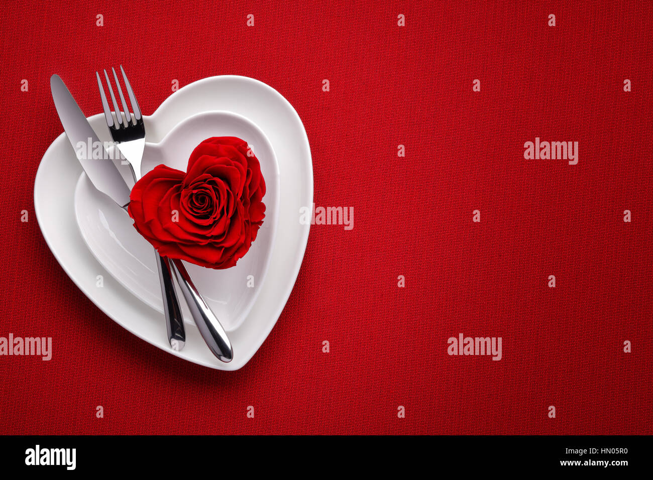 Rote Rose auf weißem Teller. Essen am Valentinstag Stockfoto