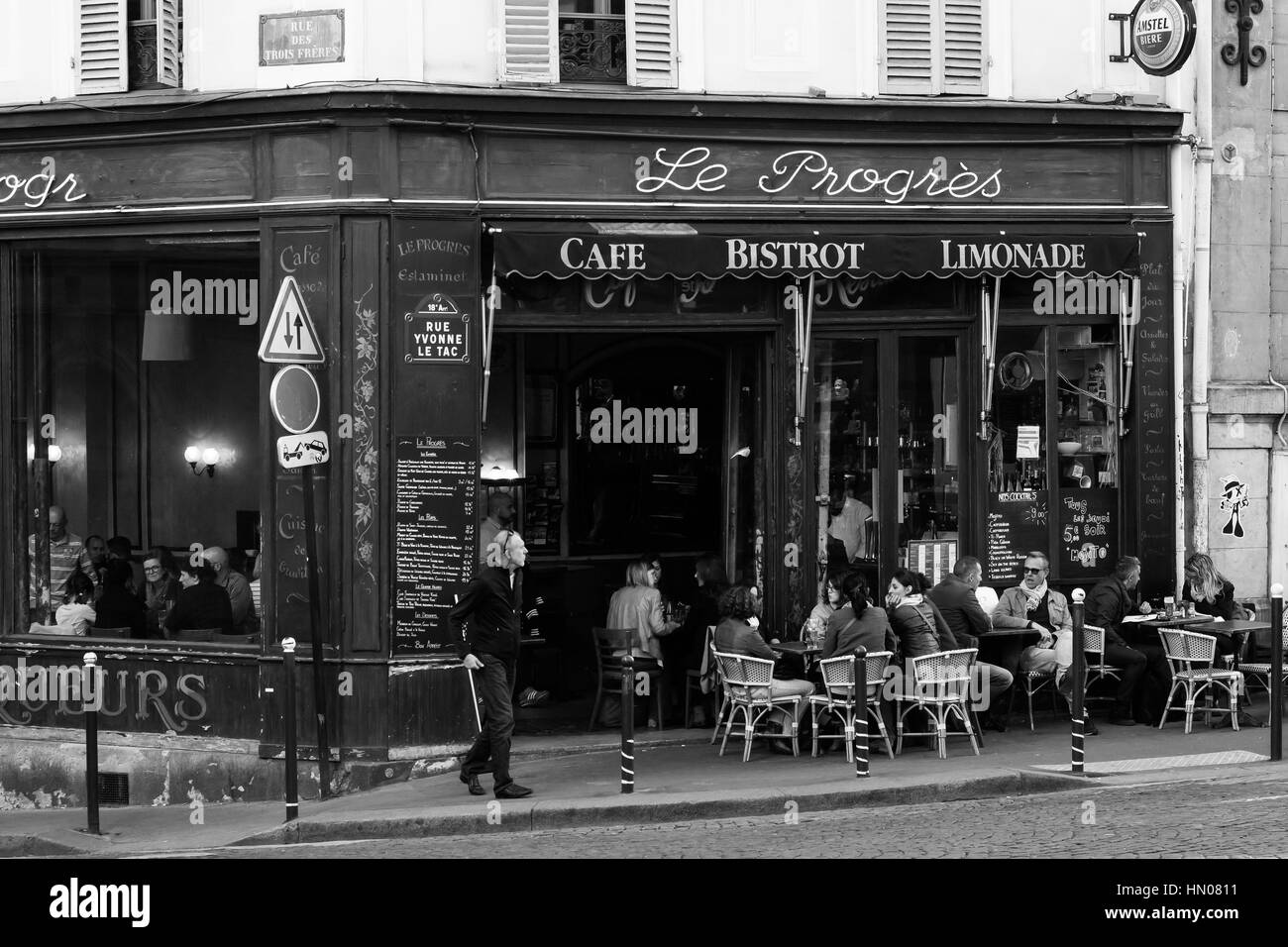 Le Progrès, ein Café-Bistro in Paris, mit Menschen, die an den Tischen im Freien sitzen. Stockfoto