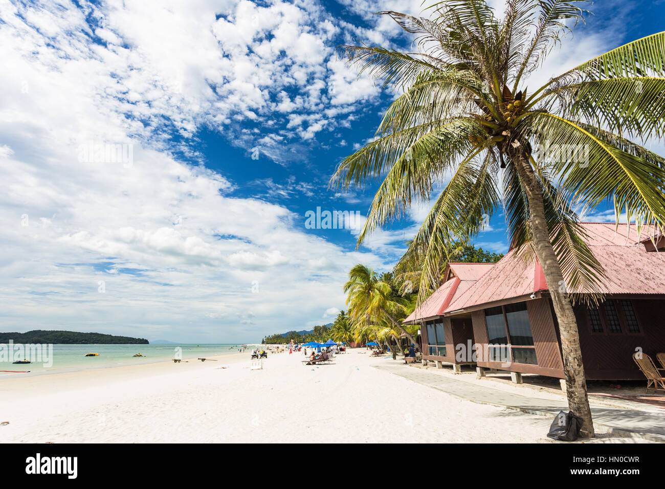 Palme und Bungalow am Pantai Cenang, der beliebteste Strand auf der Insel Langkawi entlang der Andamanensee in Malaysia Kedah Zustand. Stockfoto