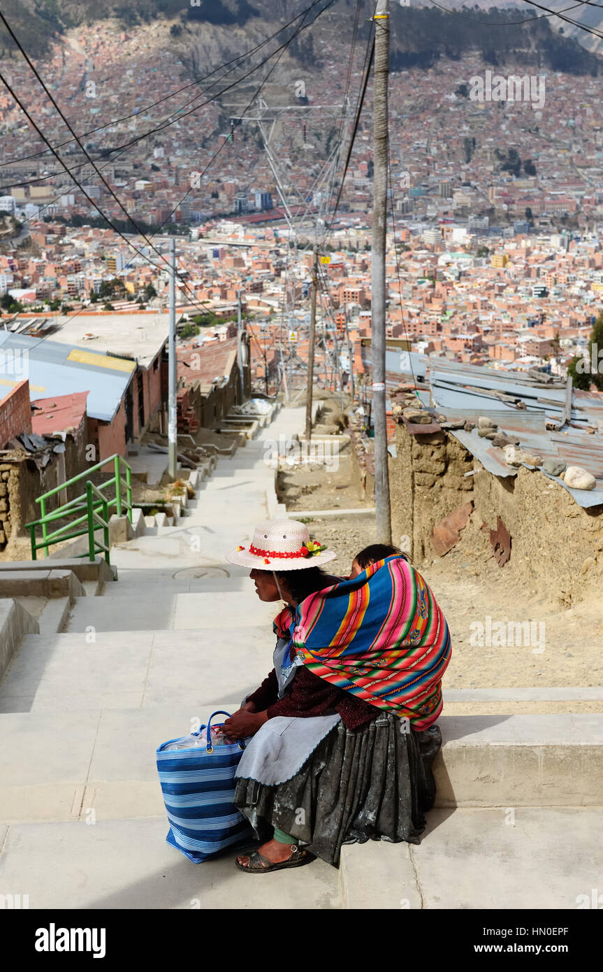 Blick auf das Zentrum La Paz aus Armenvierteln am Rande der Stadt auf 4000 m ü.m. Ebene setzen. Die Frau ruht sich auf dem Weg in die Innenstadt. Stockfoto Blick auf das Zentrum La Paz aus Armenvierteln am Rande der Stadt auf 4000 m ü.m. Ebene setzen. Die Frau ruht sich auf dem Weg in die Innenstadt. Stockfoto