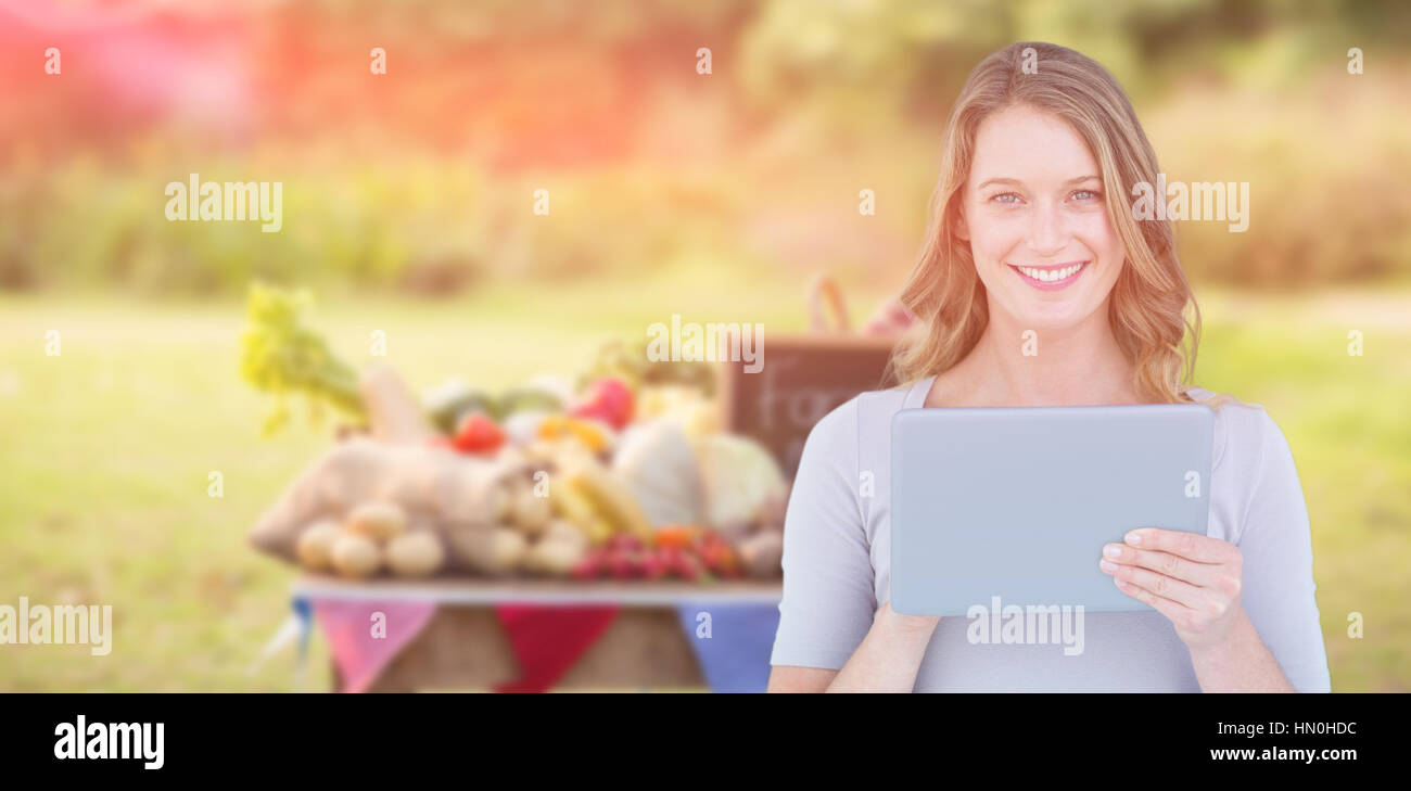 Porträt von glücklich Frau mit digital-Tablette gegen Nahrung mit Schiefer auf Tisch Stockfoto