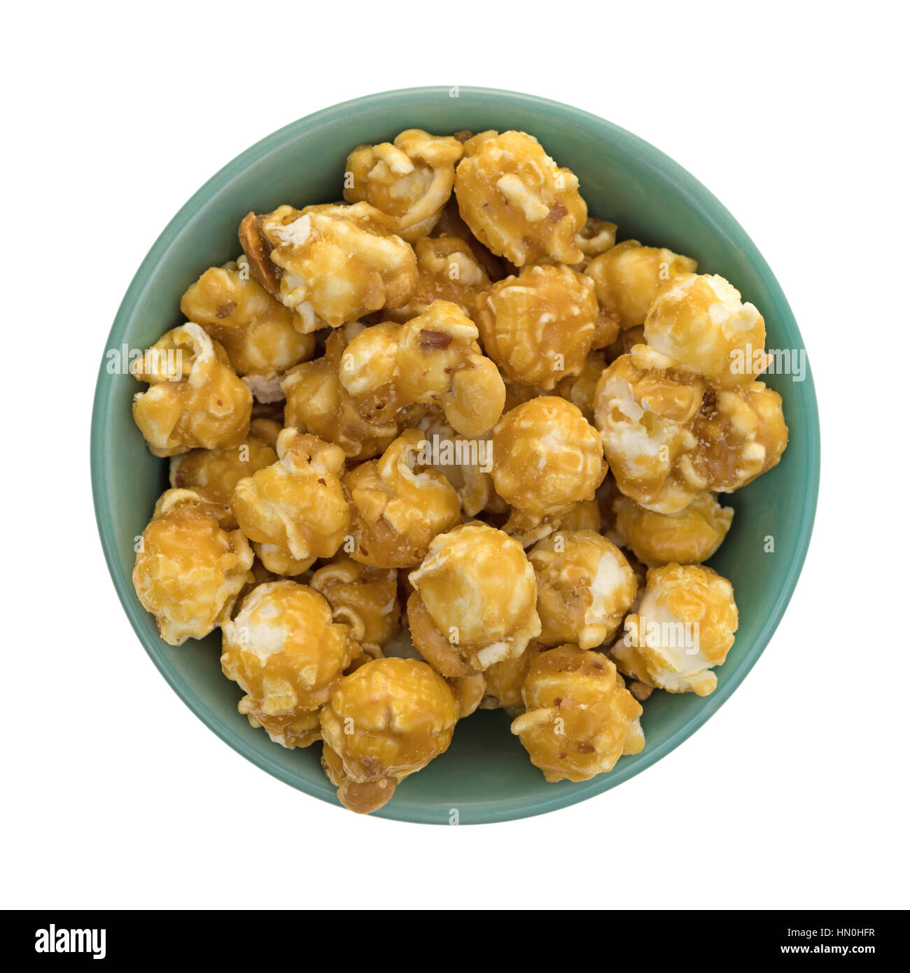 Draufsicht einer grünen Schale gefüllt mit Karamell Toffee Popcorn mit Nüssen isoliert auf einem weißen Hintergrund. Stockfoto