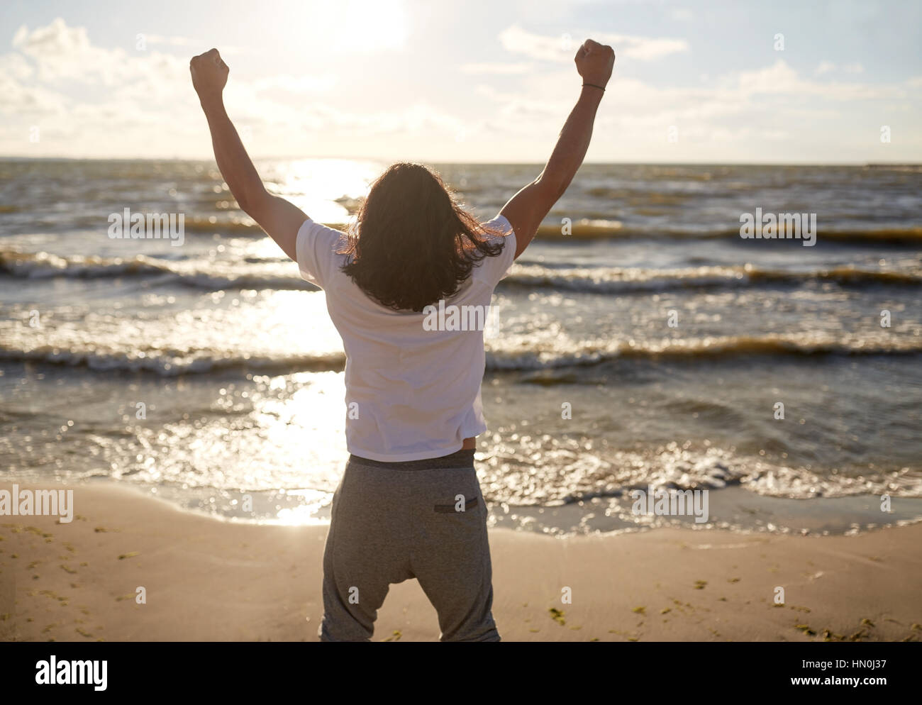 Mann mit rised Faust am Strand Stockfoto