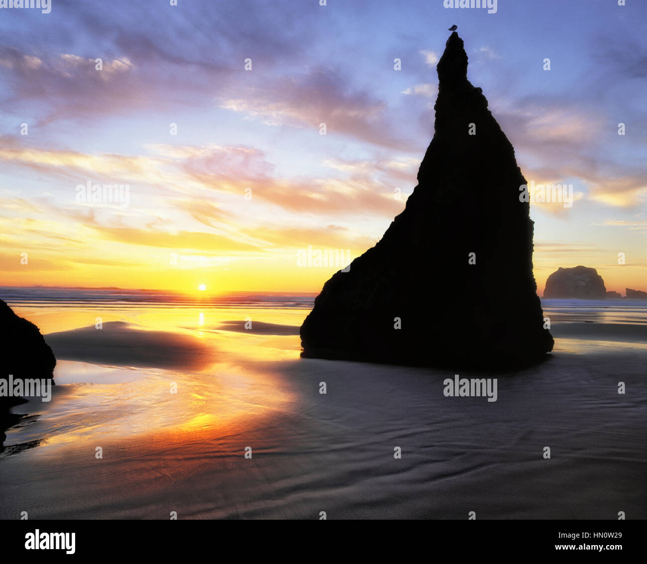 Sonnenuntergang an Oregons Südküste am Bandon Strand mit dem Meer-Stack als The Zaubererhut bekannt. Stockfoto