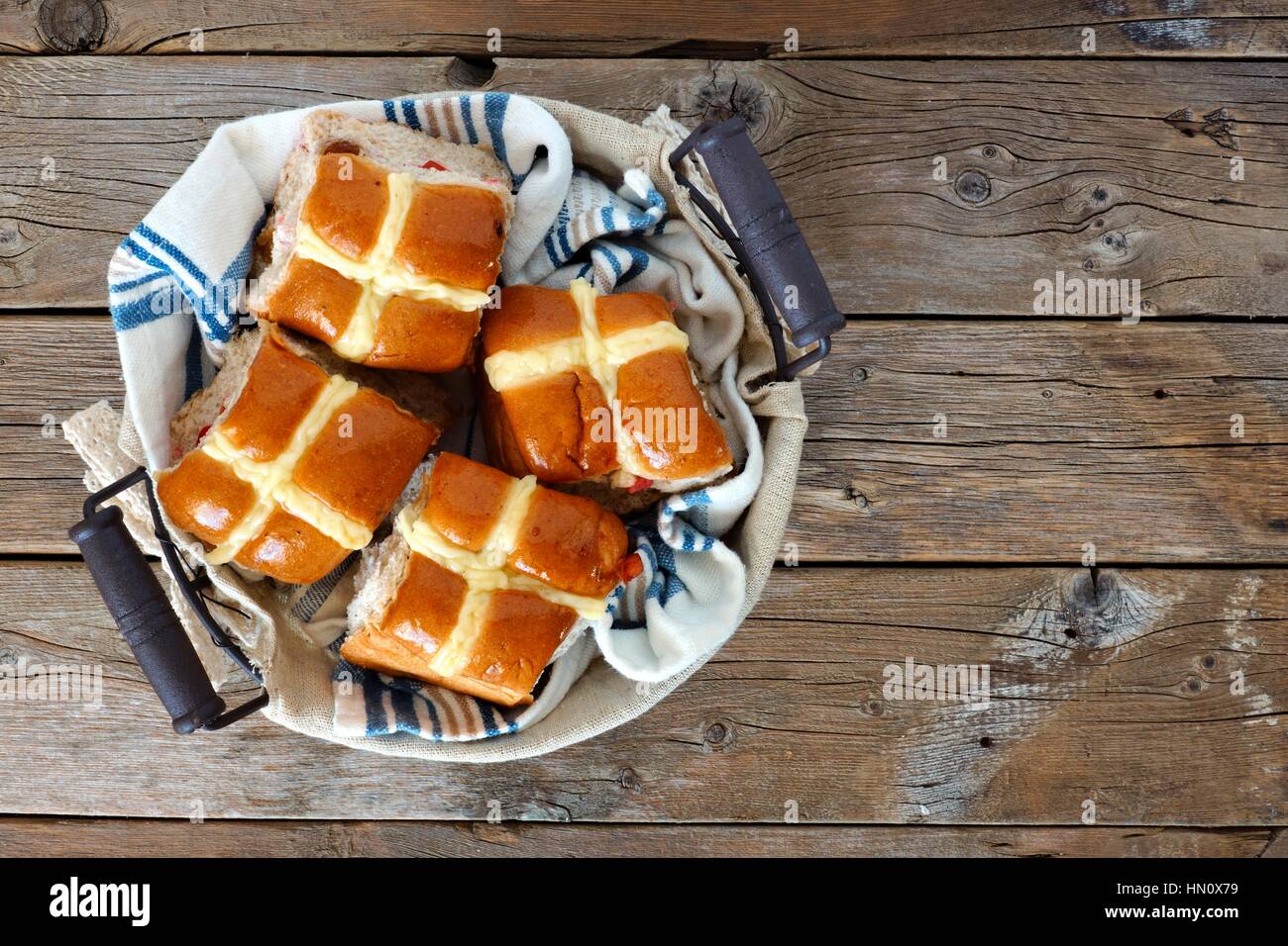 Ostern Hot Cross Buns in einem Korb, nach unten gerichtete Blick auf einem rustikalen Holz Hintergrund Stockfoto