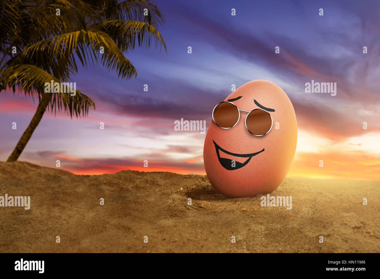 Glücklich Ostereier mit Sonnenbrille am Strand bei Sonnenuntergang Stockfoto