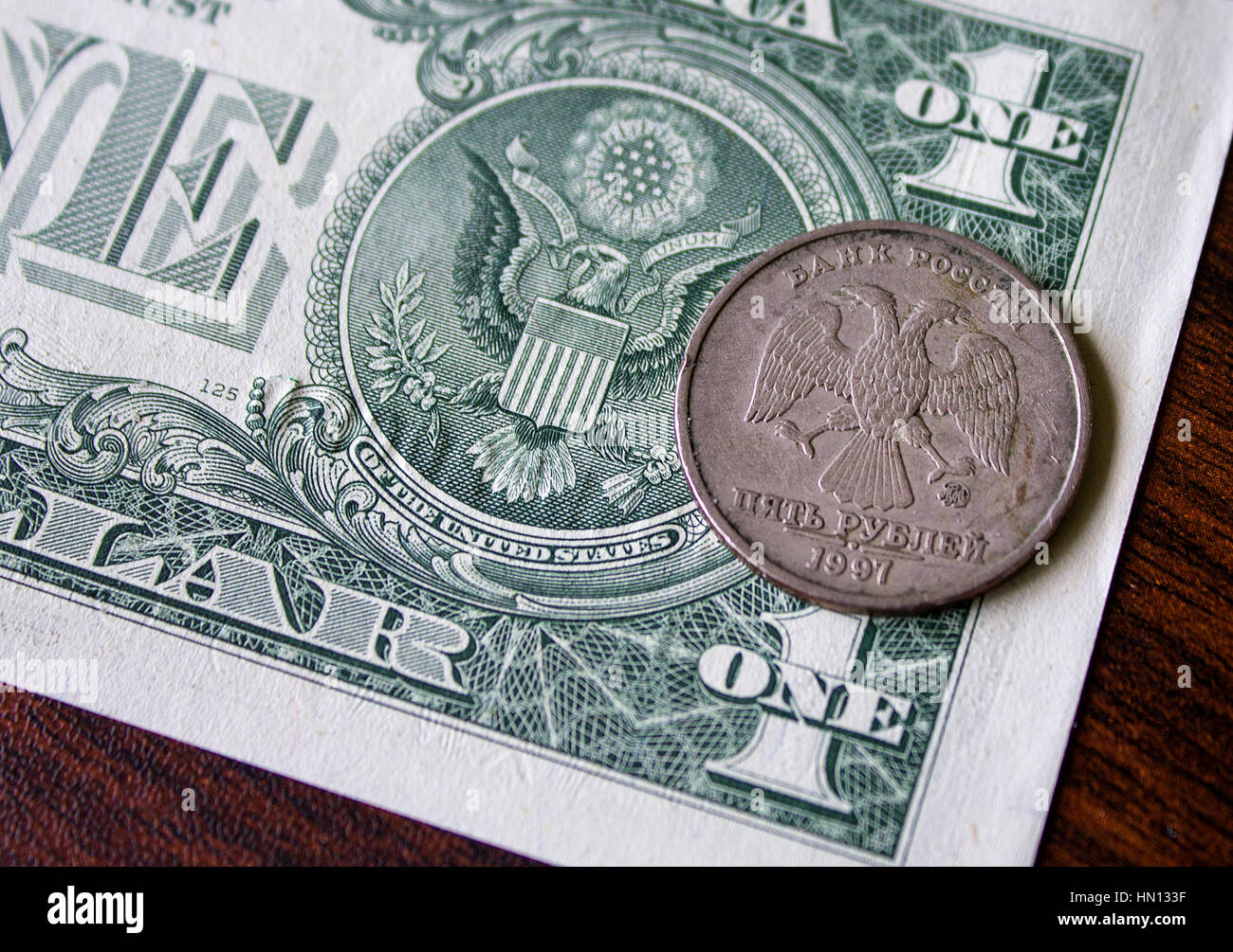 US-Dollar und russische Münze, Holzbrett Stockfoto