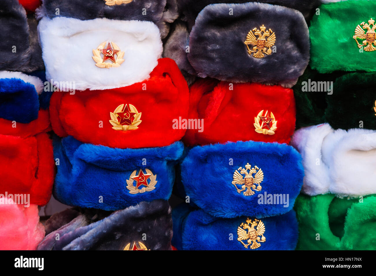 Haufen von traditionellen russischen Winter Pelz Mützen mit Ohrenklappen angezeigt als Souvenirs zu verkaufen. Rot, weiß, blau, schwarz, grüne Kappen Stockfoto