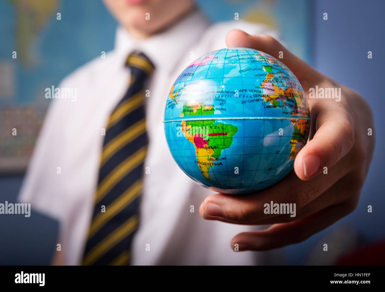 Ein Schuljunge hält einen Globus Stockfoto