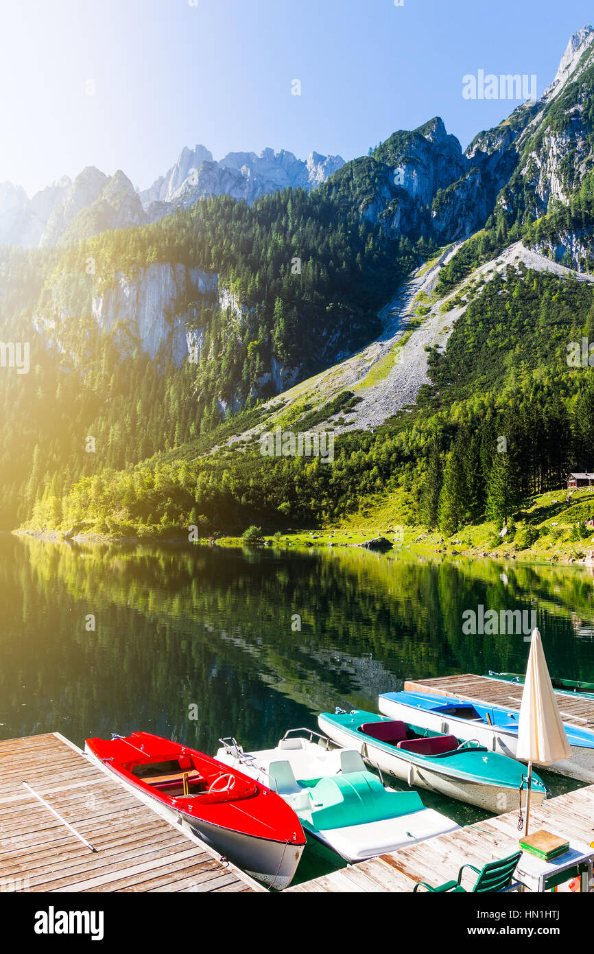 Schöne Aussicht auf die idyllische bunte Sommerlandschaft klar Gosausee Bergsee mit bunten Booten, Salzkammergut region Stockfoto