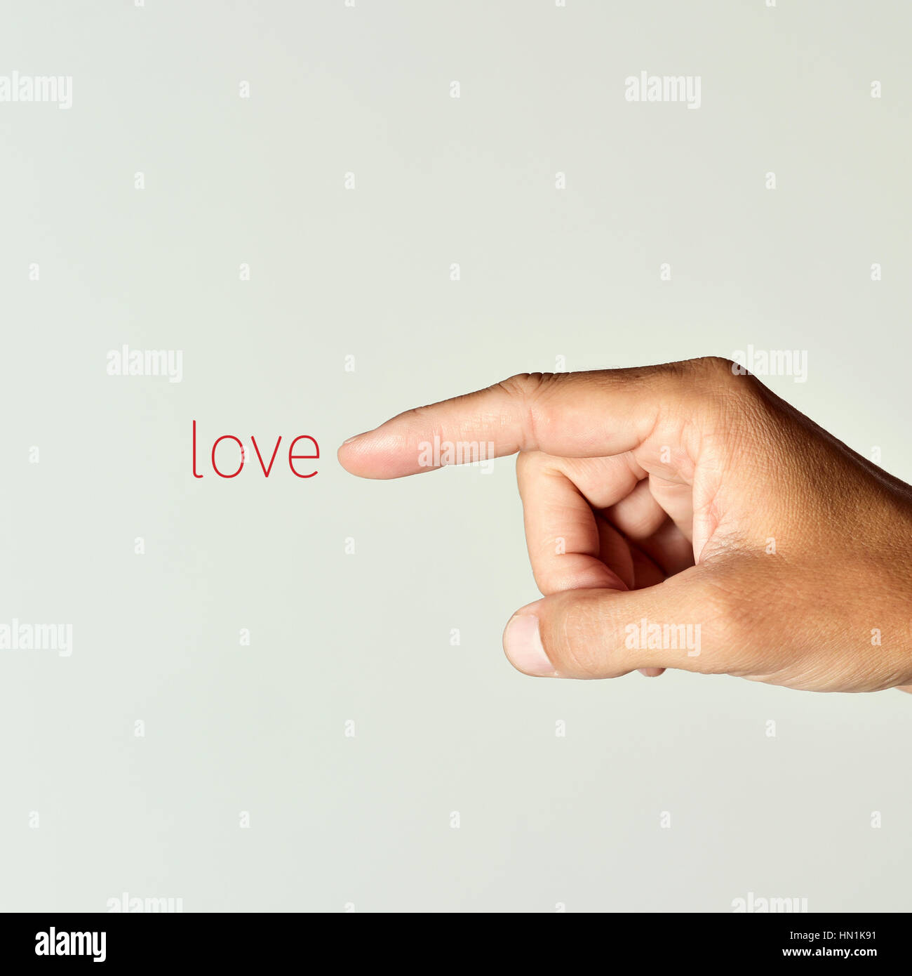 Nahaufnahme von den Zeigefinger eines kaukasischen Jünglings verweist das Wort Liebe, eine wollweiße Hintergrund Stockfoto