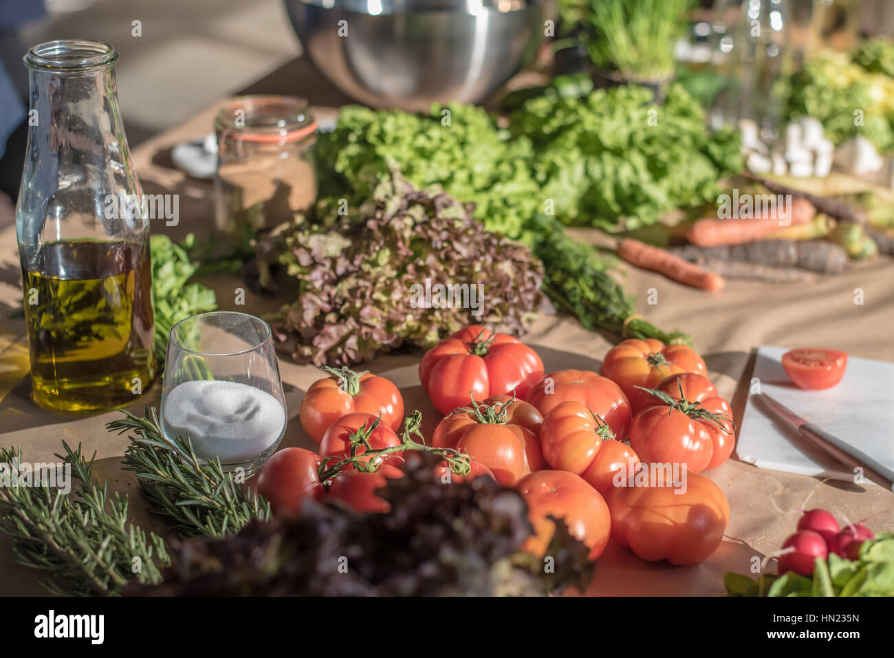 frische Lebensmittel Gemüse und eine Flasche Olivenöl auf einem Tisch Stockfoto