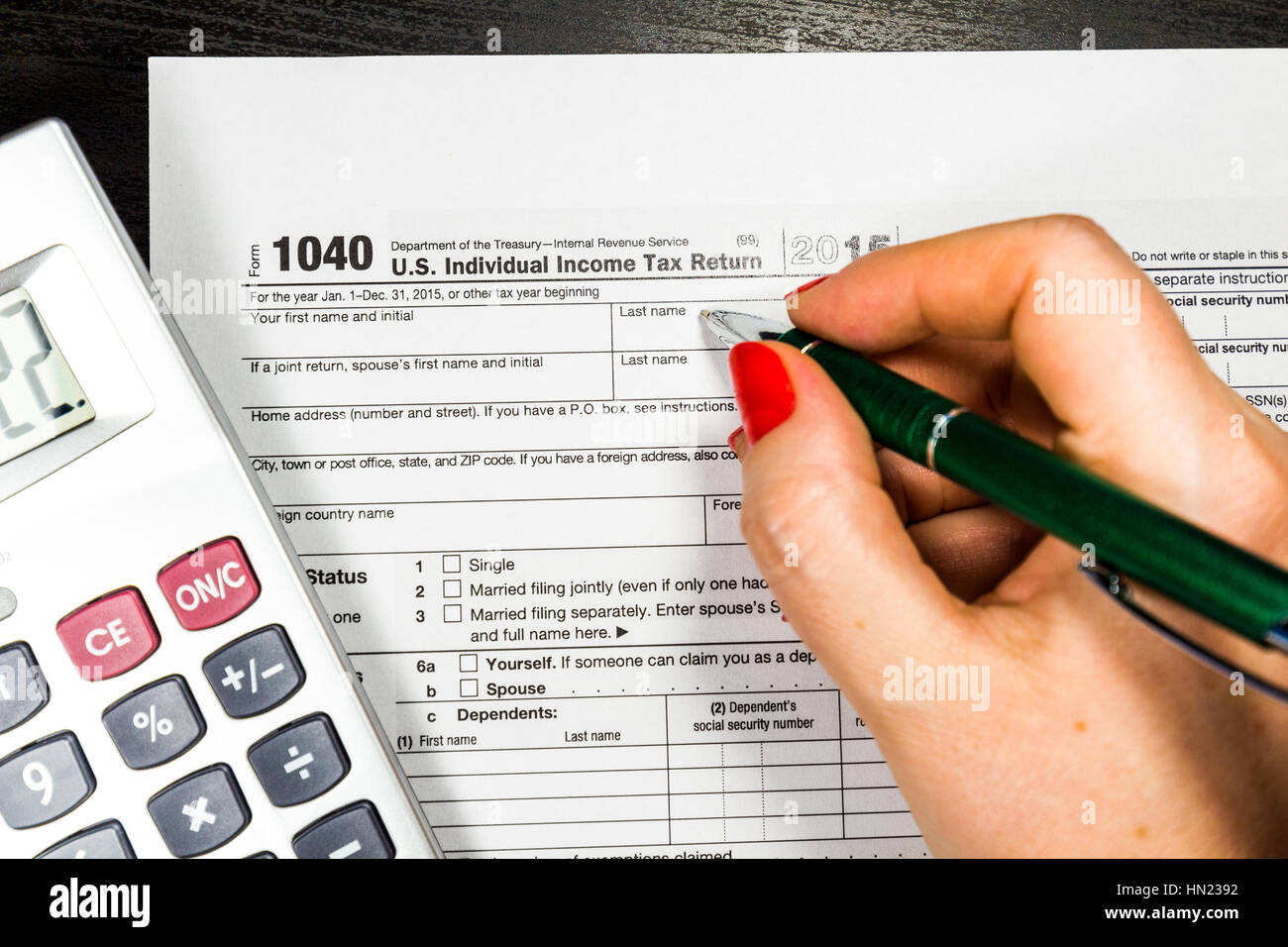 Business-Frau füllt das Steuerformular 1040 mit Stift und Taschenrechner Stockfoto
