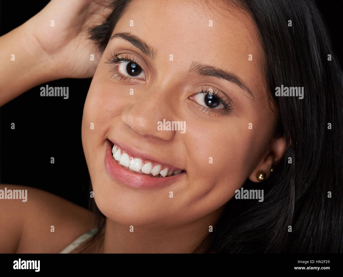 Kopfschuss des Lächelns Latina Mädchen isoliert auf schwarz Stockfoto