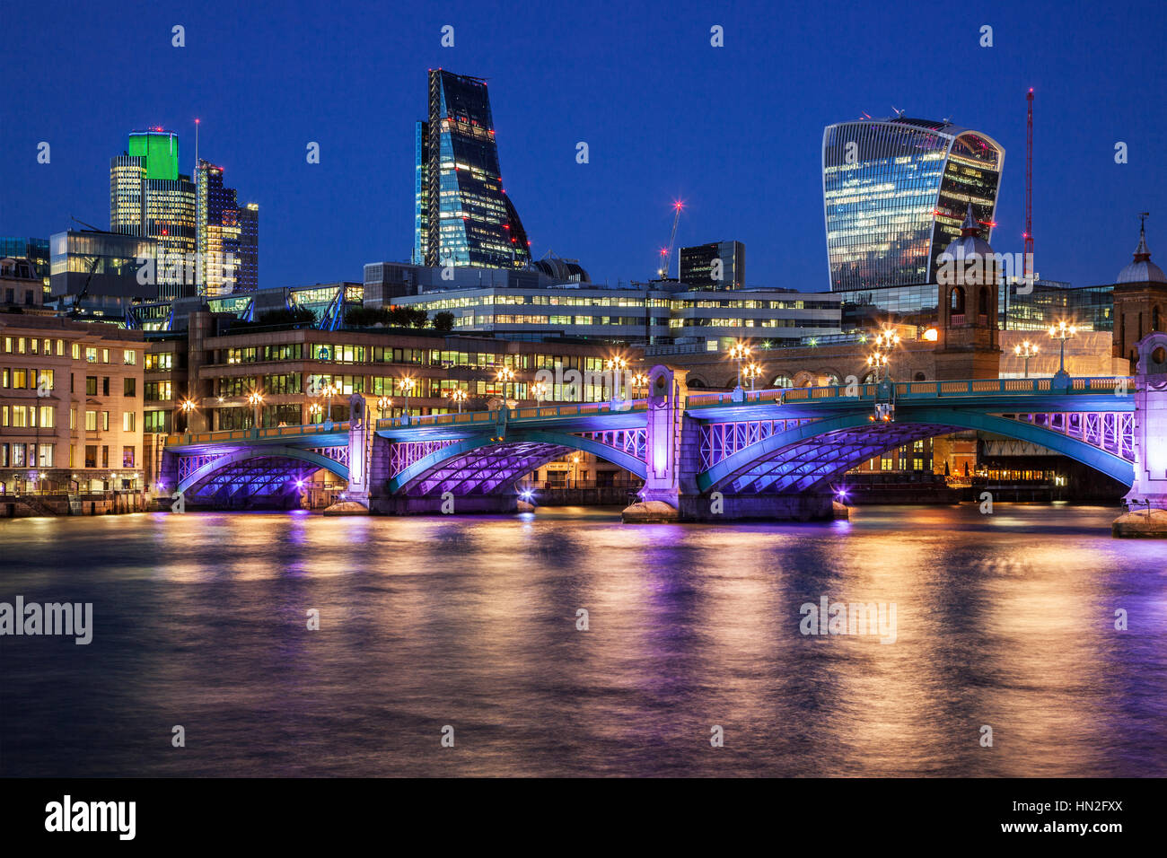 Nachts auf der Themse an der Southwark Bridge in London mit den "Cheesegrater" und "Walkie Talkie" Gebäuden im Hintergrund. Stockfoto