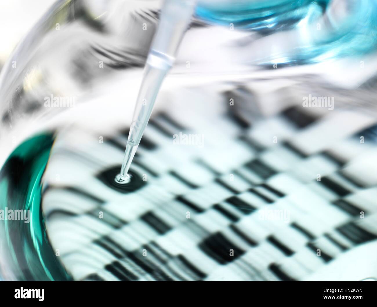 Genetikforschung. Pipette und Kanne vor einer DNA (Desoxyribonukleinsäure) Autoradiogram. Stockfoto