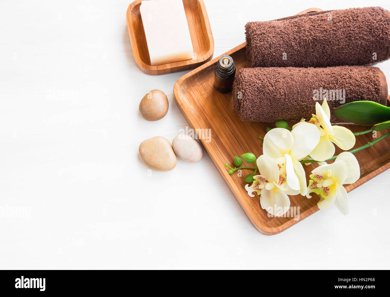 Spa-Einstellung mit Orchidee Blume, Handtücher, Seife und Massage Steinen, über Kopf gedreht Stockfoto
