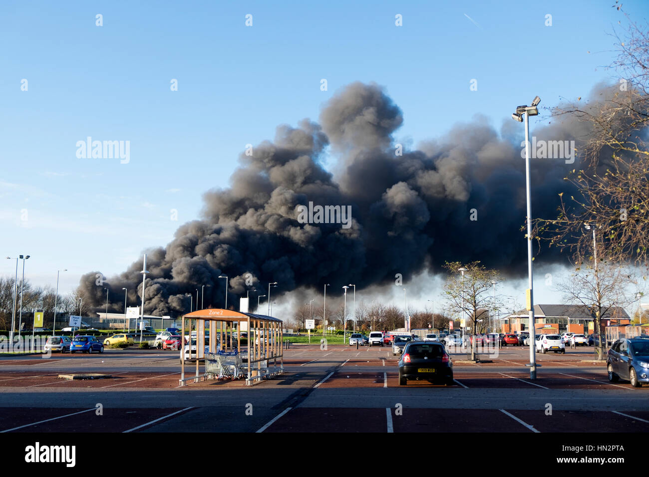 Großes Fabrikfeuer mit dicken schwarzen Rauchwolken Stockfoto