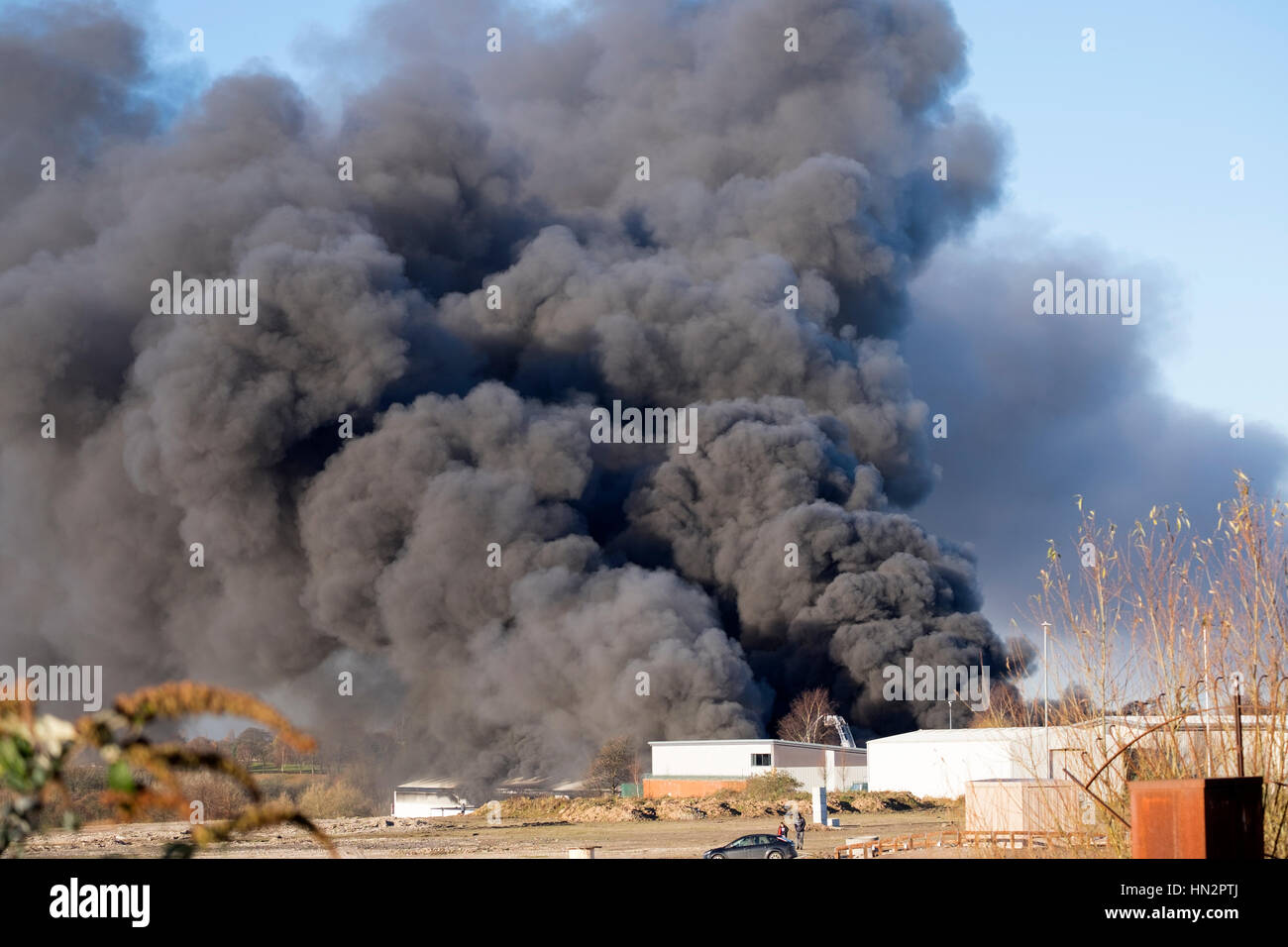 Großes Fabrikfeuer mit dicken schwarzen Rauchwolken Stockfoto