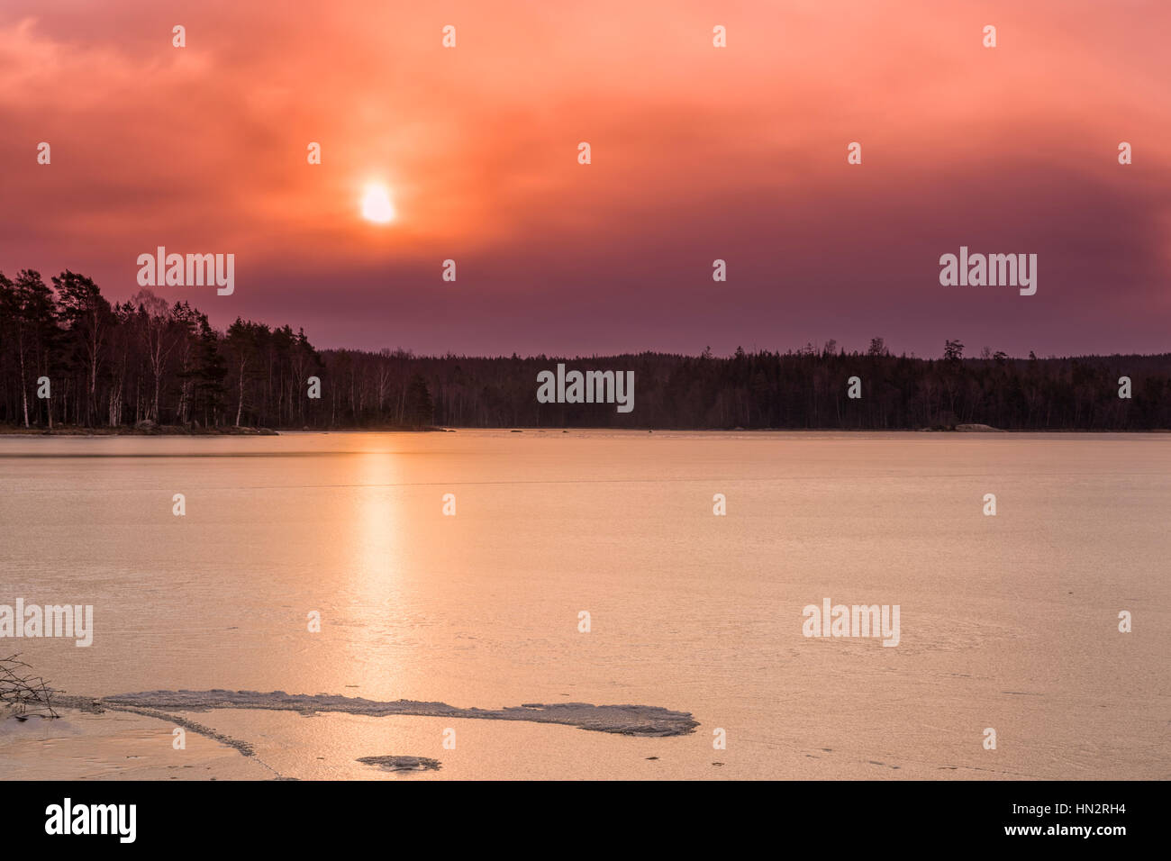 Schöne lebendige Morgen Sonnenaufgang Winterlandschaft an gefrorenem Eis bedeckten See Uspen, Schweden Model Release: Nein Property Release: Nein. Stockfoto