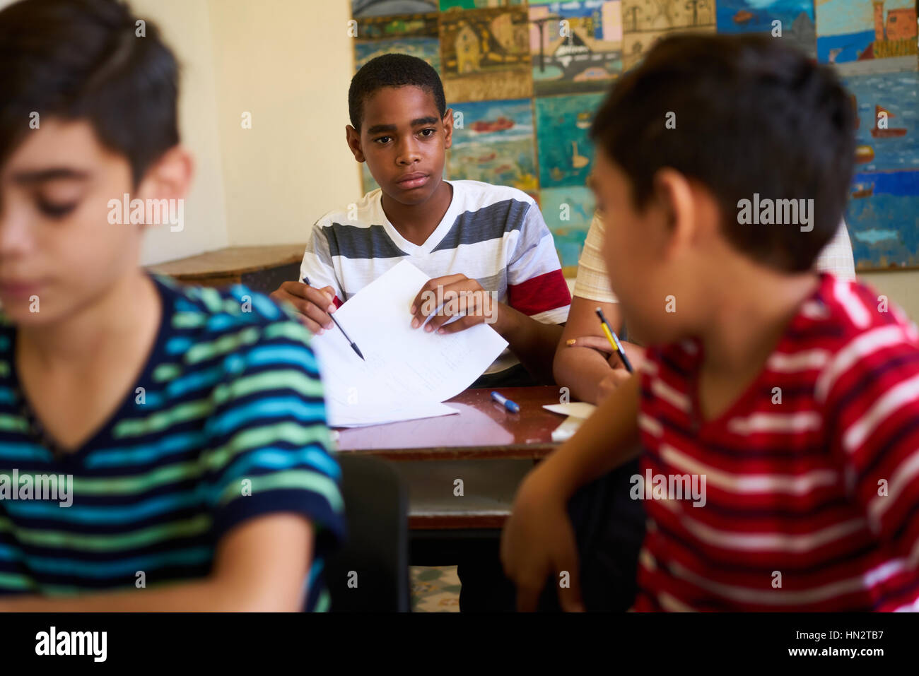 Jugend und Bildung. Gruppe von hispanic Studenten in der Klasse in der Schule während der Lektion. Frustriert jungen betrug während der Aufnahme-Test, Prüfung Stockfoto