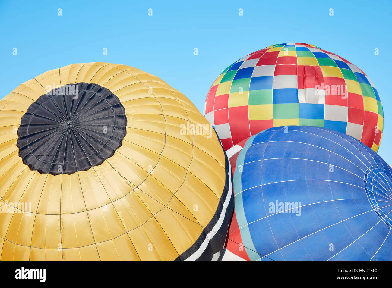 Bunte Heißluftballons Aufblasen auf Boden, blauer Himmel Stockfoto