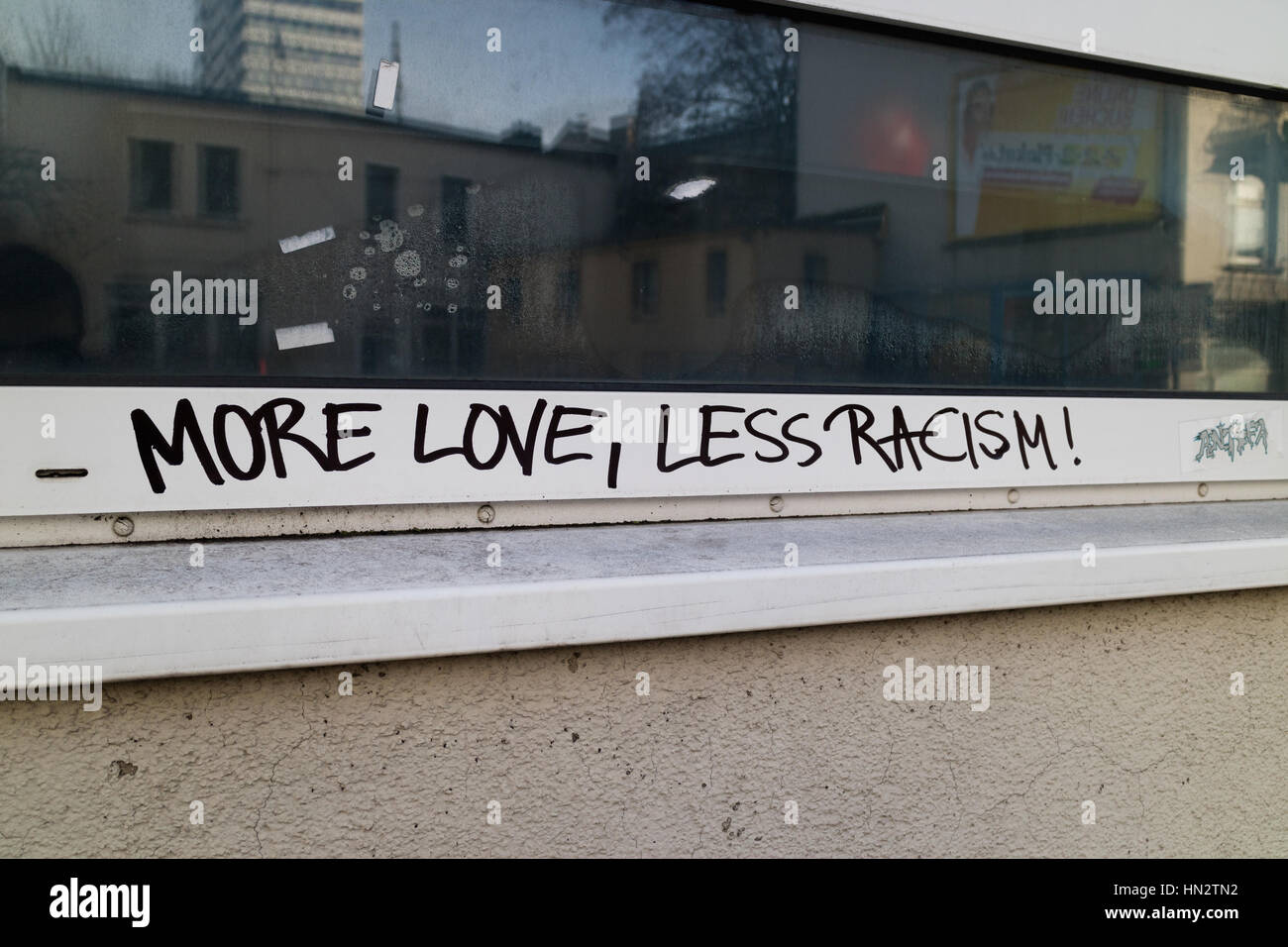 Graffiti auf einem Gebäude sagt mehr Liebe, weniger Rassismus Stockfoto